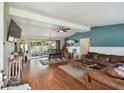 Spacious living room with hardwood floors, a ceiling fan, and sliding glass doors to the patio at 1707 Cardinal Dr, Clearwater, FL 33759