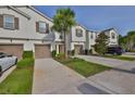 Inviting townhome featuring a lush lawn, mature tree, and private driveways and garages at 17834 Althea Blue Pl, Lutz, FL 33558
