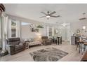 Bright living room with wood floors, comfortable seating, ceiling fan, and natural light from large windows at 2032 Inverness Greens Dr # 76, Sun City Center, FL 33573
