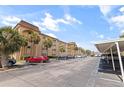 Beige two-story condominium complex with palm trees, parking spaces, and blue skies on a sunny day at 2525 W Bay Dr # B43, Belleair Bluffs, FL 33770