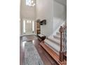 Bright foyer showcasing hardwood flooring, staircase, and high ceilings with natural light at 26972 Evergreen Chase Dr, Wesley Chapel, FL 33544