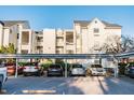 Condominium buildings are seen behind a sheltered parking structure with multiple parked cars at 3127 W Sligh Ave # 303B, Tampa, FL 33614