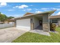 Lovely single-story home featuring a two-car garage, stone veneer details, and a welcoming entrance with tiled walkway at 3301 Tuckahoe Pl, Holiday, FL 34690