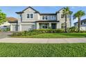 This spacious, neutral-toned home has a three-car garage and mature landscaping in the front yard at 33075 Kateland Dr, Wesley Chapel, FL 33545