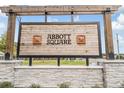 Welcoming community sign for Abbot Square with rustic wooden details and stone base at 36414 Well Hill Way, Zephyrhills, FL 33541
