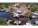 An aerial view of a waterfront home with a private dock and boat lift on a canal at 386 Westwinds Dr, Palm Harbor, FL 34683