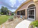 Inviting walkway leading to the home's entrance with beautiful plants and welcoming decor at 386 Westwinds Dr, Palm Harbor, FL 34683