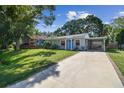 Charming single-story home featuring a bright blue door and a covered parking area with a concrete driveway at 4009 S Renellie Dr, Tampa, FL 33611