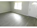 Bright living room with wood-look flooring and a white front door with a window at 4417 Kohler St, New Port Richey, FL 34652