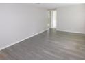 Open floor plan living room with wood-look flooring and neutral wall paint at 4417 Kohler St, New Port Richey, FL 34652