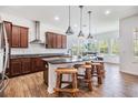 Gourmet kitchen featuring granite countertops, stainless steel appliances, and a center island with bar seating at 4716 Butler National Dr, Wesley Chapel, FL 33543