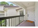 Stylish condo entry featuring a covered landing, a white door, and a 'so happy you're here' welcome mat at 4735 Winslow Beacon # 14, Sarasota, FL 34235