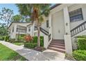 Exterior view of a charming condo building with a manicured lawn and mature palm trees at 4735 Winslow Beacon # 14, Sarasota, FL 34235
