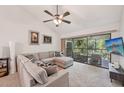 Bright living room with large sectional, ceiling fan, and screened lanai access for outdoor living at 4735 Winslow Beacon # 14, Sarasota, FL 34235