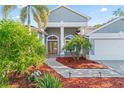 Inviting front entrance with double doors, arched windows, and well-maintained landscaping at 4959 Felecity Way, Palm Harbor, FL 34685