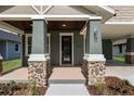 Close-up of the front porch with stone pillars and a dark wood front door at 5703 N 20Th St, Tampa, FL 33610