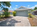 Suburban home with a two-car garage, a concrete driveway, and landscaping beneath a partly cloudy sky at 7534 Oxford Garden Cir, Apollo Beach, FL 33572