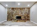 Living room features a large stone fireplace with hearth and wood-look flooring at 8330 Lafitte Dr, Hudson, FL 34667