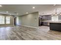 Open-concept living room with wood-look tile and seamless access to kitchen at 8330 Lafitte Dr, Hudson, FL 34667