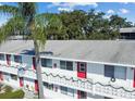 Close up of a white two-story building with red doors and holiday themed outdoor decor at 8425 112Th St # 203, Seminole, FL 33772