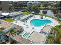 Aerial view of outdoor community pool and recreation area with umbrellas and lounge chairs at 8425 112Th St # 203, Seminole, FL 33772