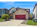 Two story home with a red garage door, well maintained lawn, and a landscaped walkway at 8747 Flourish Dr, Land O Lakes, FL 34637