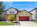Beautiful two-story home with a red garage door, a meticulously maintained lawn, and an inviting, landscaped entrance at 8747 Flourish Dr, Land O Lakes, FL 34637