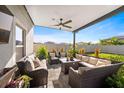Inviting covered patio area with comfortable wicker furniture, a ceiling fan, and serene backyard views at 9334 Lemon Drop Loop, Sun City Center, FL 33573