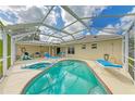 Backyard screened-in pool and spa area with lounge chairs and patio space at 1857 N San Mateo Dr, North Port, FL 34288