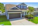 Charming two-story home featuring an attached garage, manicured landscaping, and a welcoming front porch area at 11307 Quiet Forest Dr, Tampa, FL 33635