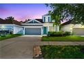 Beautiful two-story home with a two-car garage and well-maintained lawn at dusk at 11307 Quiet Forest Dr, Tampa, FL 33635