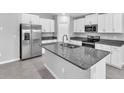 Well lit kitchen with granite countertops, stainless steel appliances and a central island with a sink at 12907 Wildflower Meadow Dr, Riverview, FL 33579