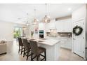 Bright, modern kitchen with white cabinetry, quartz countertops and stainless steel appliances at 13157 Peachleaf Ave, Riverview, FL 33579