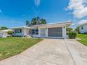 Attractive one-story home featuring a well-manicured lawn and long concrete driveway at 14045 90Th Pl, Seminole, FL 33776