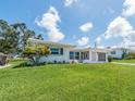 Well-kept one-story home with a verdant front lawn and a freshly painted white exterior at 14045 90Th Pl, Seminole, FL 33776