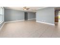 Spacious living room featuring neutral tile flooring, ceiling fan, and large windows at 14045 90Th Pl, Seminole, FL 33776