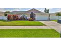 Charming front yard of the house with well-manicured lawn and colorful shrubs at 2021 Elk Spring Dr, Brandon, FL 33511