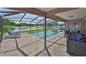 Covered backyard pool area overlooking the lake and featuring outdoor seating at 2021 Elk Spring Dr, Brandon, FL 33511