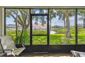 Inviting screened-in porch with a view of lush greenery and the tranquil waterfront, ideal for relaxation at 2363 Hanover Dr, Dunedin, FL 34698