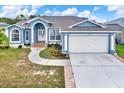 Charming single-story home with a well-manicured lawn and a two-car garage at 23917 Pow Wow Dr, Lutz, FL 33559
