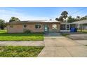 Street view of a single-story home with a turquoise door, solar panels, and landscaped yard at 2501 18Th S Ave, St Petersburg, FL 33712