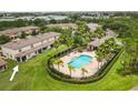 Aerial view of the community pool and clubhouse, surrounded by lush landscaping and palm trees at 2628 Oleander Lakes Dr, Brandon, FL 33511