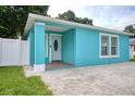 Covered front porch with turquoise walls, white trim, and a brick-paved entrance at 2715 Bel Aire Cir, Tampa, FL 33614