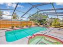 Relaxing screened-in pool area includes a heated pool, hot tub, patio furniture, and lush landscaping at 2861 Pinellas Point S Dr, St Petersburg, FL 33712