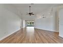 Spacious living room with vaulted ceilings, ceiling fans, and wood-look flooring at 304 Caloosa Palms Ct, Sun City Center, FL 33573