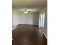 Spacious living room featuring dark, wood-look tile flooring and a ceiling fan with sliding door access to the outdoors at 337 S Mcmullen Booth Rd # 157, Clearwater, FL 33759