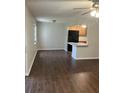 Open-concept living room leading to kitchen, complete with wood-look tile flooring and natural light from a window at 337 S Mcmullen Booth Rd # 157, Clearwater, FL 33759