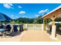 A relaxing outdoor patio features a grill, seating, and a scenic view of the surrounding greenery at 3501 Pine Top Dr, Valrico, FL 33594