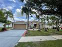 Charming single-story home featuring a well-manicured lawn, complemented by lush tropical landscaping and a two car garage at 3501 Pine Top Dr, Valrico, FL 33594