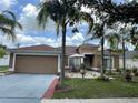 Charming single-story home featuring a well-manicured lawn, complemented by lush tropical landscaping and a two car garage at 3501 Pine Top Dr, Valrico, FL 33594